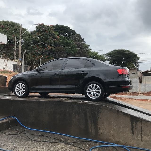 Jetta preto molhado sobre a rampa de lavagem