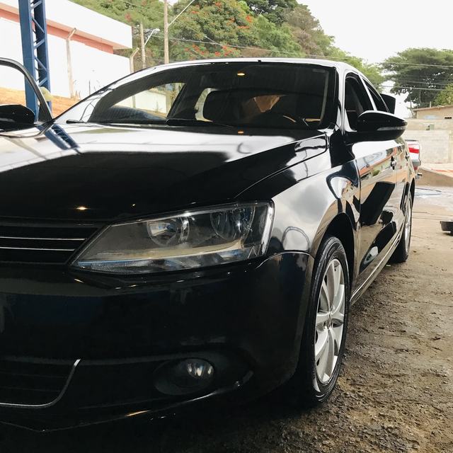 Frente de um Jetta preto com a pintura brilhando